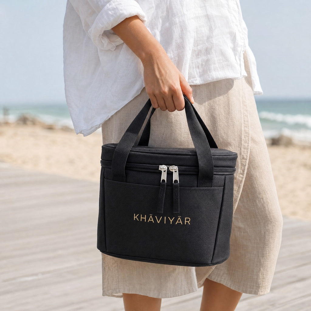KHAVIYAR Caspian Cooler Bag carried by the handles on a coastal boardwalk