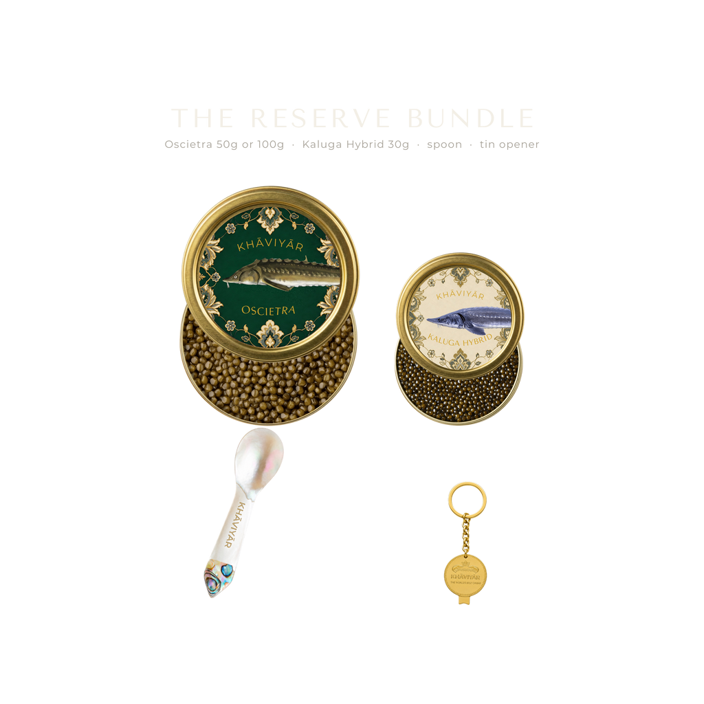 The KHAVIYAR reserve bundle line up: a large Oscietra tin, a small Kaluga Hybrid tin, a mother of pearl caviar spoon and the bespoke tin opener keychain.